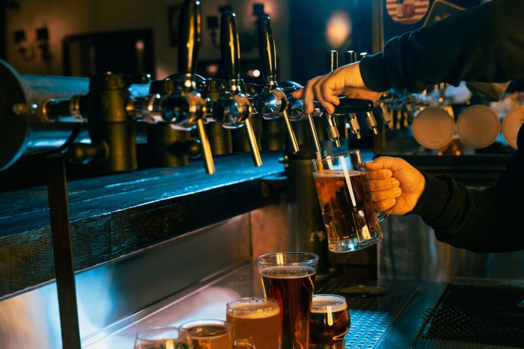 Bartender pouring draft beer at bar representing Missouri liquor license requirements for bars and restaurants served by Brydon Swearengen, England, Jefferson City